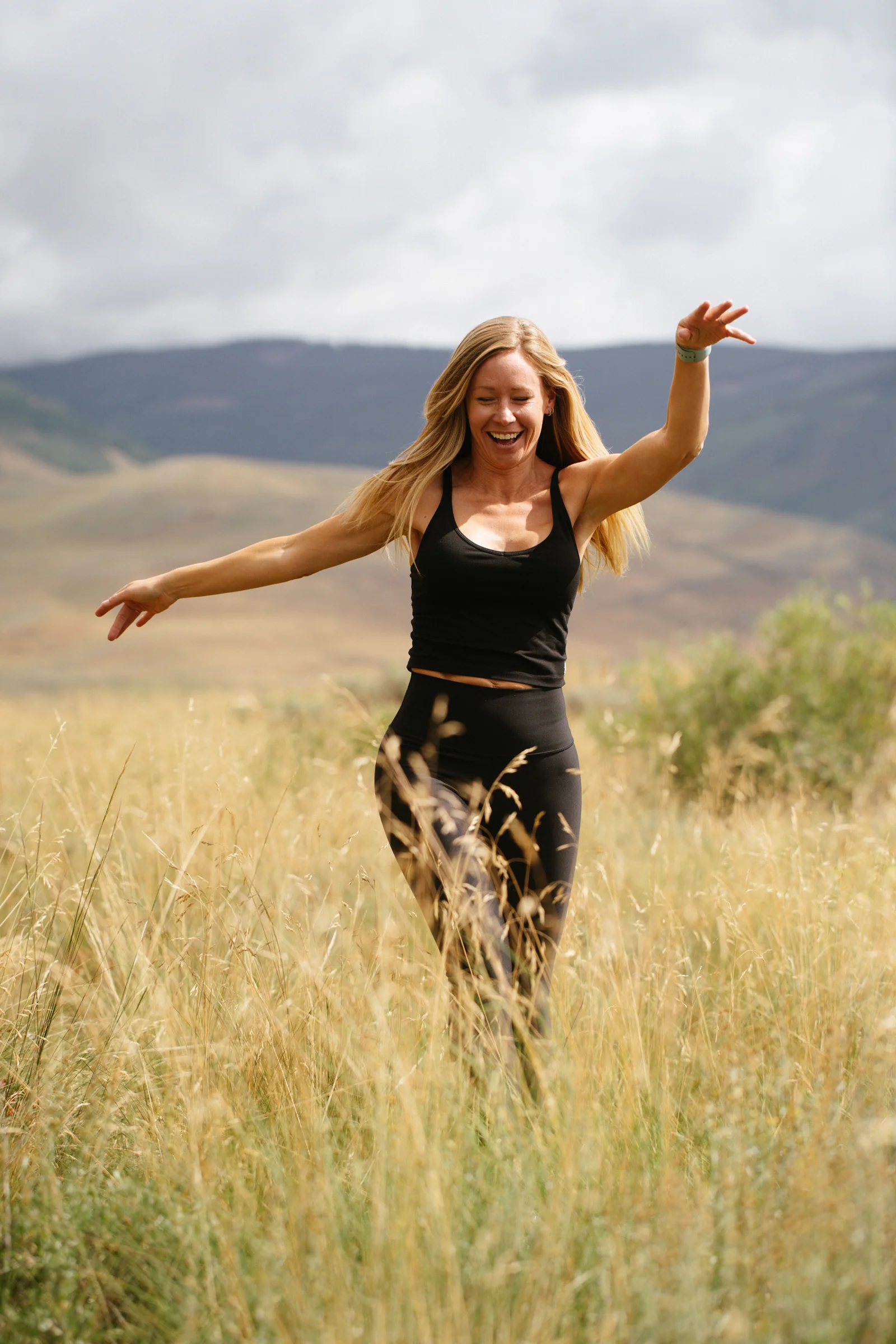 Kate moving through tall grass in the mountains